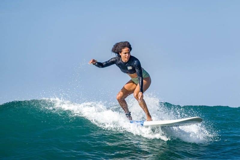 An intermediate surfer riding a clean green wave at Weligama Bay, Sri Lanka