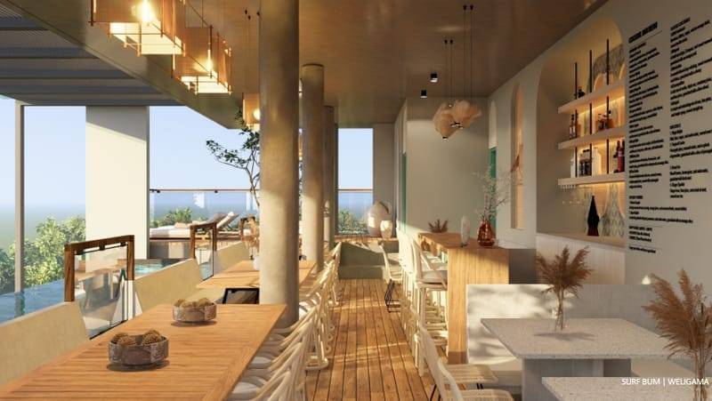 Open-sided rooftop restaurant with long timber tables beside the pool at Soul Surfer Camp, Weligama
