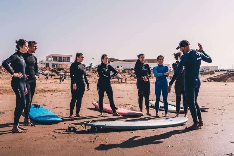 Surf coach talking a group through the session at Tamraght, Morocco