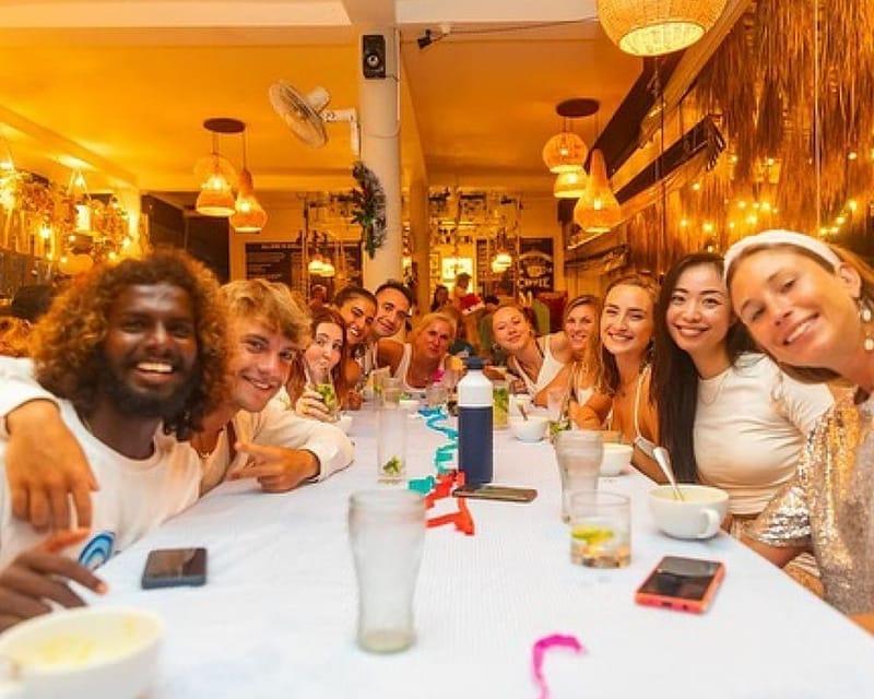 Camp guests together at the long dinner table in the restaurant at The Surfer, Weligama, Sri Lanka