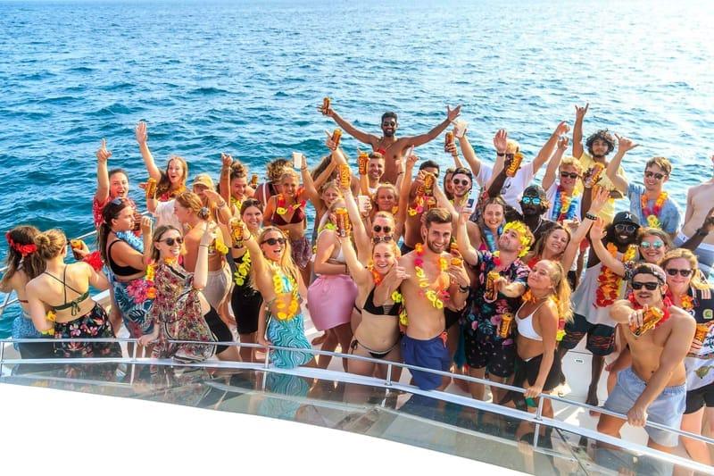 Camp guests in flower leis on the deck of The Surfer boat party, south coast Sri Lanka