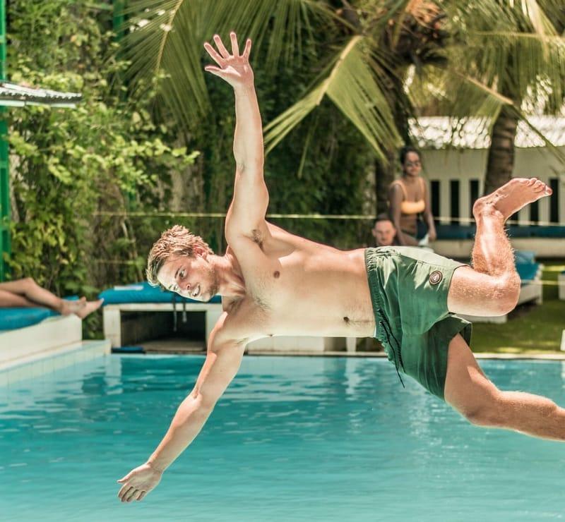 A guest jumping into the swimming pool at The Surfer Beach Camp, Weligama