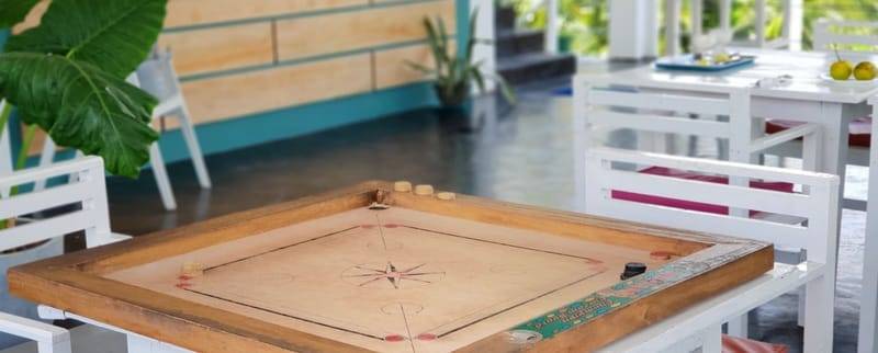 A carrom board set up in the shared common area at The Surfer TS2 Camp, Weligama, Sri Lanka